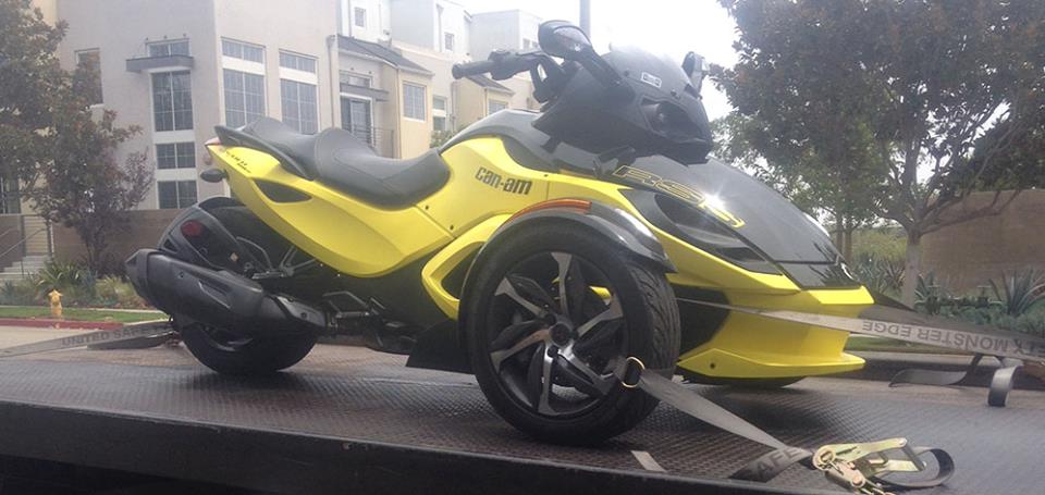 Cheap-towing-services-Van-Nuys A yellow and black three wheeled motorcycle parked on the street.