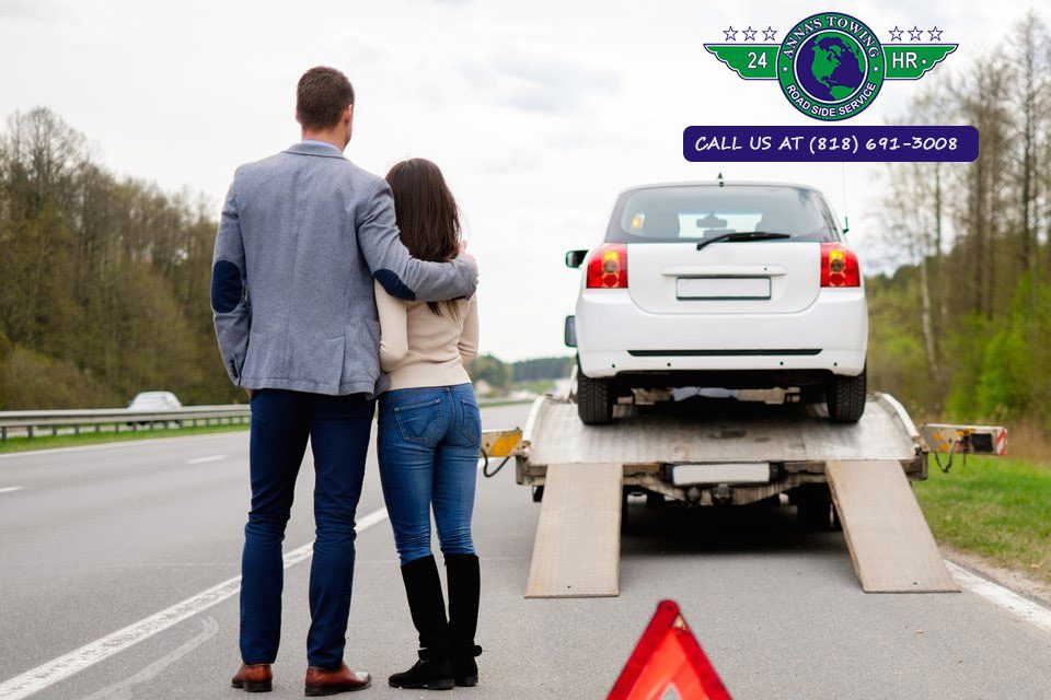 Comprehensive-Toluca-Lake-and-Sherman-Oaks-Towing A man and woman standing next to a car on the road.