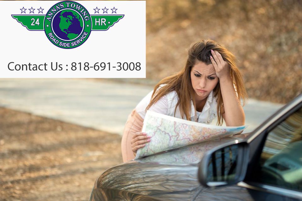 Does-My-Insurance-Policy-Cover-Towing-in-Santa-Clarita A woman sitting on the ground looking at a map.