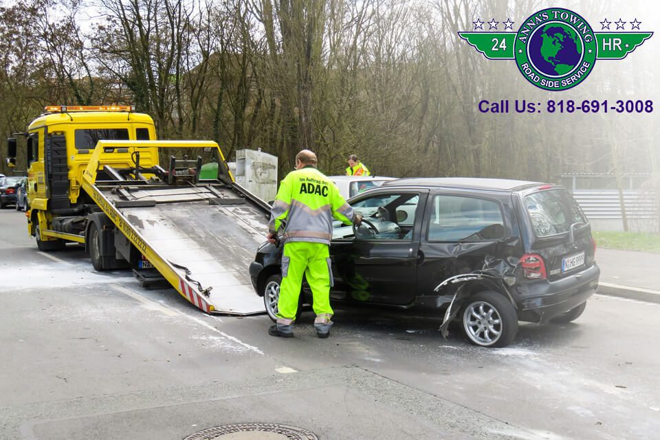 Valley-Village-Towing-1 Tow truck loading damaged black car.