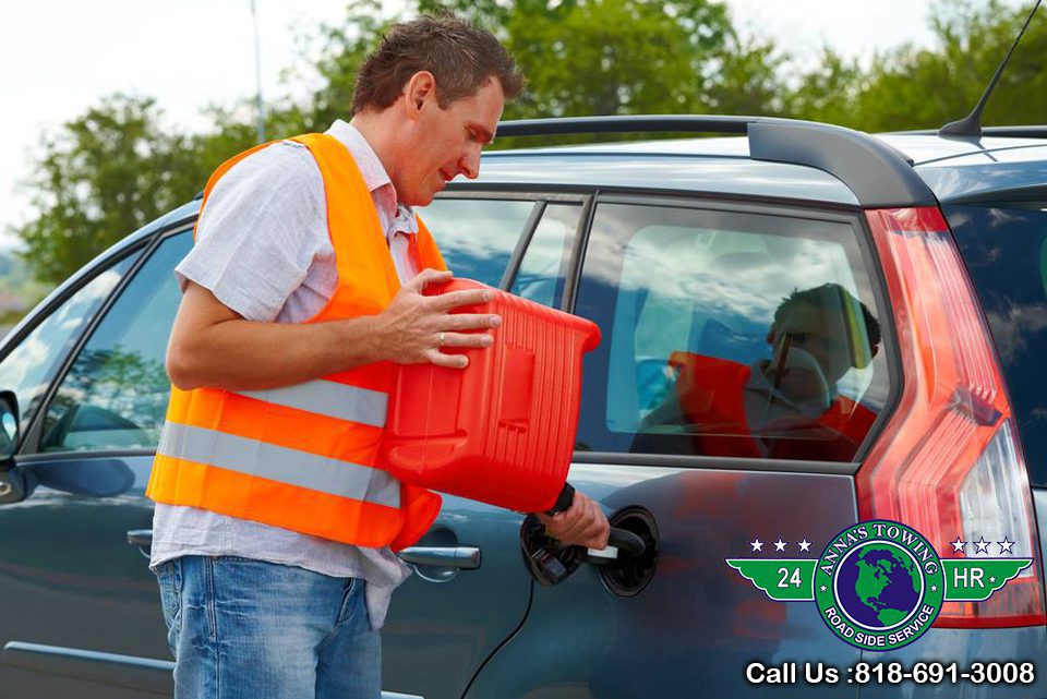 Valley-Village-Towing-Or A man in an orange vest holding onto a red container.