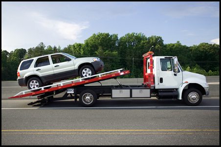 towing-northridge A tow truck is carrying a car on the road.