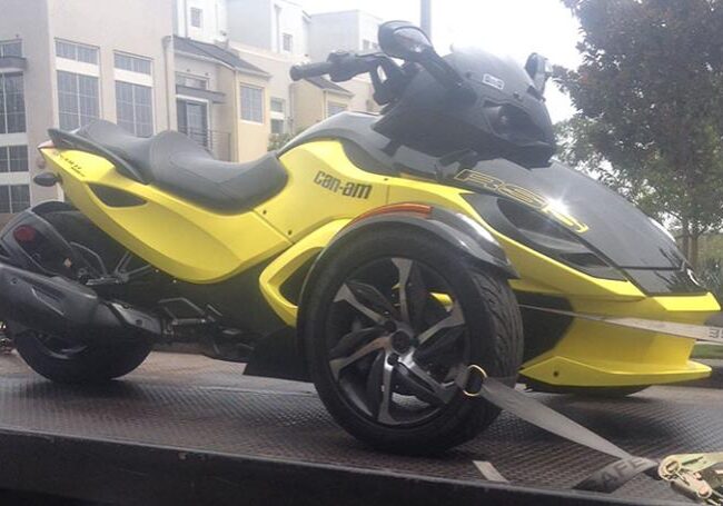 Cheap-towing-services-Van-Nuys A yellow and black three wheeled motorcycle parked on the street.