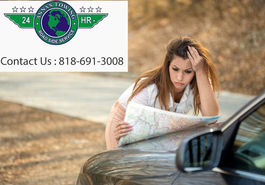 A woman sitting on the ground looking at a map.