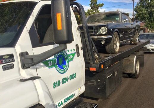 A tow truck towing a car on the road