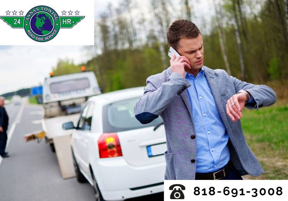 Stay-Safe-Thanks-to-Santa-Clara-Towing A man on the side of the road talking to someone on his phone.
