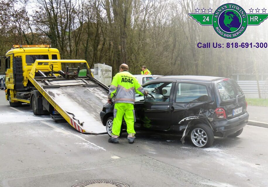 Valley-Village-Towing-1 Tow truck loading damaged black car.