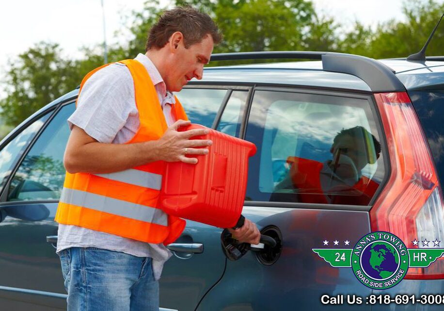 Valley-Village-Towing-Or A man in an orange vest holding onto a red container.