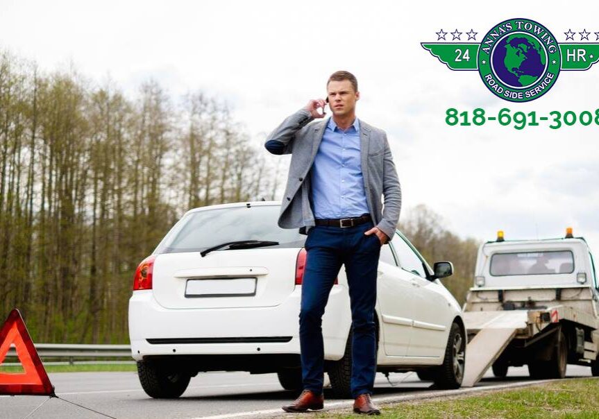 When-You-Need-Emergency-Valley-Village-Towing A man standing on the side of a road talking on his phone.